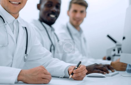 Téléchargez les photos : Médecin expérimenté assis à la table du laboratoire - en image libre de droit