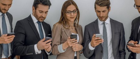 Foto de Grupo de gente de negocios mirando las pantallas de sus teléfonos inteligentes - Imagen libre de derechos