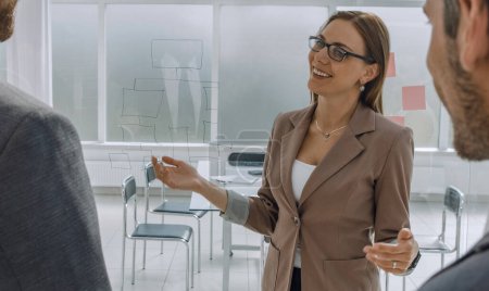 Téléchargez les photos : "femme d'affaires parlant à des partenaires d'affaires dans son bureau" - en image libre de droit