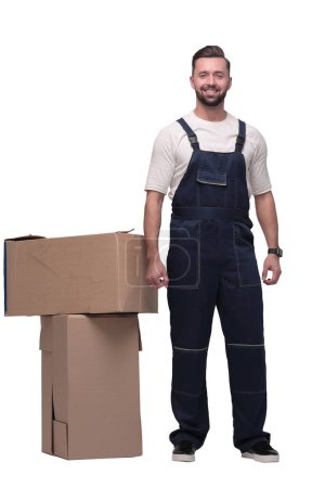 Téléchargez les photos : En pleine croissance. homme souriant debout près des boîtes en carton - en image libre de droit