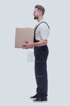 Photo for Side view. smiling man passing a cardboard box - Royalty Free Image