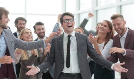 Téléchargez les photos : Homme d'affaires heureux debout parmi ses collègues. - en image libre de droit