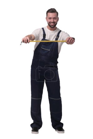 Photo for "in full growth. smiling man with construction tape measure" - Royalty Free Image