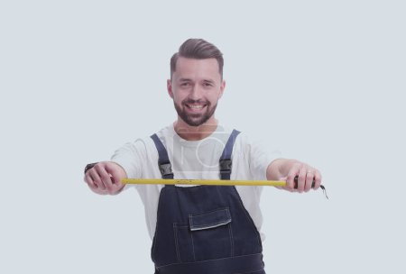 Photo for In full growth. smiling man with construction tape measure - Royalty Free Image