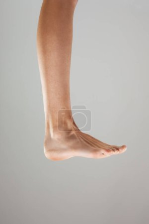 Foto de Sexy piernas femeninas contra fondo gris. - Imagen libre de derechos