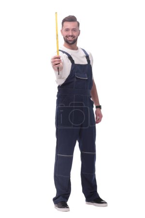 Photo for "man in overalls with a construction tape measure. isolated on white" - Royalty Free Image