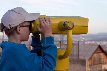 Foto de Chico mirando a través de binocular en la ciudad - Imagen libre de derechos