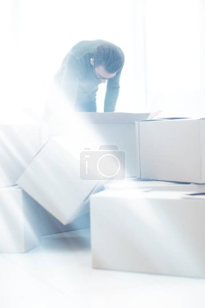 Photo for "man examining the box in the new house" - Royalty Free Image