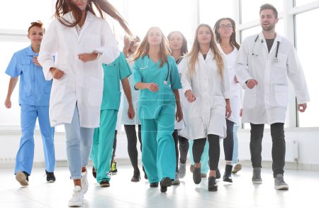 Téléchargez les photos : "groupe de médecins stagiaires hilarants marchant à l'hôpital - en image libre de droit