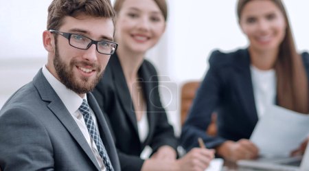 Téléchargez les photos : Employés et hommes d'affaires assis derrière un bureau - en image libre de droit