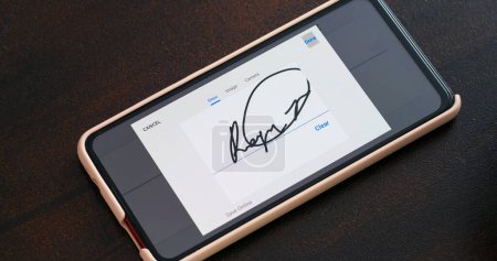 Téléchargez les photos : "Signature électronique avec écran de téléphone" - en image libre de droit