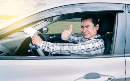 Photo for "Portrait of a man showing thumbs up while driving, Man in his car giving a thumbs up, happy man in his car giving a thumbs up" - Royalty Free Image