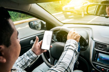 Foto de "Distracted driver using the cell phone while driving, Man using his phone while driving, Person holding the cell phone and with the other hand the steering wheel, Concept of irresponsible driving" - Imagen libre de derechos