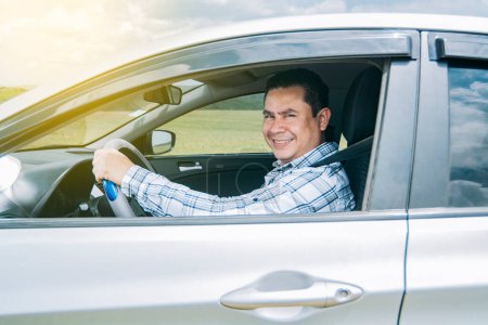 Photo for "man smiling at the camera in his car, man smiling happily in his car, image of a person smiling and happy driving a car and looking at the camera" - Royalty Free Image
