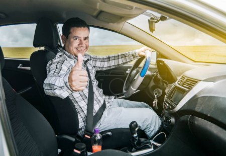 Téléchargez les photos : "L'homme dans sa voiture donne un pouce" - en image libre de droit
