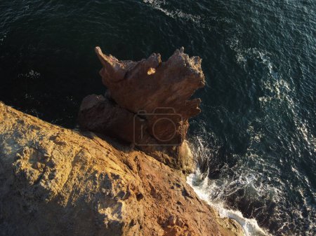 Photo for "Dragon head arise from the water - The rock or lava formation with the shape of a large animal. Popular travel destination volcanic rock formation in the shape of a dragon's head." - Royalty Free Image