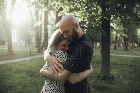 Photo for "loved ones hug tightly in the summer sun in the park. glare of the sun. soft effect" - Royalty Free Image