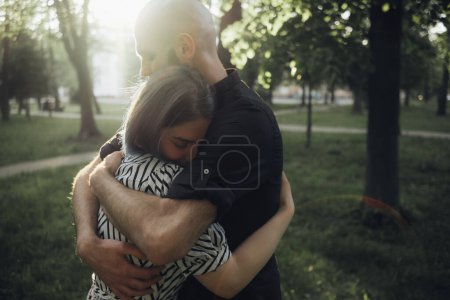 Téléchargez les photos : "les proches se serrent dans leurs bras sous le soleil d'été dans le parc. éblouissement du soleil. effet doux" - en image libre de droit