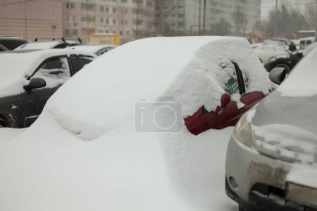 Photo for "Frozen cars in parking lot. Cars were covered with snow. After snowstorm." - Royalty Free Image