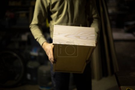 Photo for "Box of wood in hand. Production of furniture from boards." - Royalty Free Image