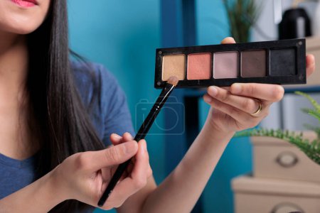 Téléchargez les photos : "Beauté gourou tenant palette cosmétique montrant à la caméra" - en image libre de droit