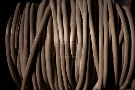 Photo for "White wire wound on reel. Tools in garage. Electrical wire tester. Dusty thing. Tangle of rope." - Royalty Free Image