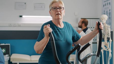 Photo for "Portrait of senior woman doing physical therapy on stationary bicycle" - Royalty Free Image
