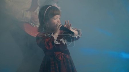 Téléchargez les photos : Little girl in vintage dress sings on stage, her father plays an electric guitar - en image libre de droit