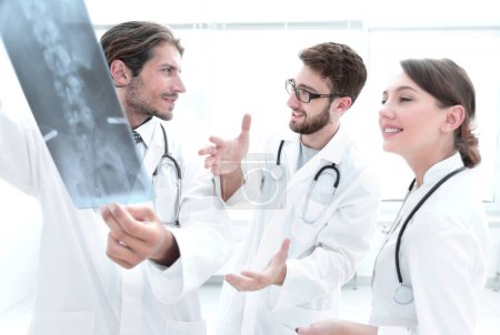 Foto de Tres doctores confiados examinan una radiografía - Imagen libre de derechos