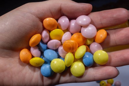 Téléchargez les photos : Petits bonbons ronds colorés en heand - en image libre de droit