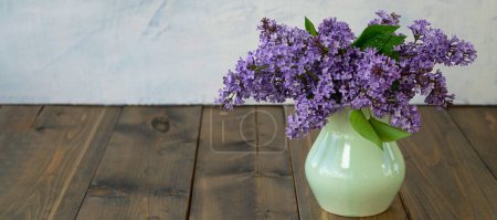 Téléchargez les photos : "bannière avec fleurs de lilas dans un vase sur une table en bois. le concept de l'été, le printemps, la nature fleurissent." - en image libre de droit