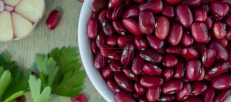 Photo for "banner with close-up of red beans in a white cup with spices on a wooden table." - Royalty Free Image