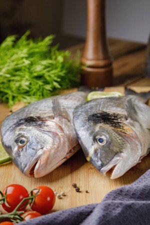 Photo for "Fresh dorado fish, on a wooden board, two heads close-up" - Royalty Free Image