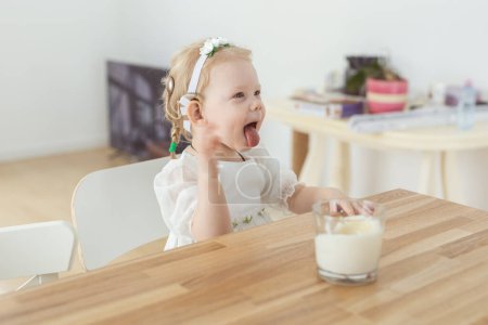Foto de "El bebé con audífonos e implantes cocleares juega con velas. Concepto sordo y de salud" - Imagen libre de derechos