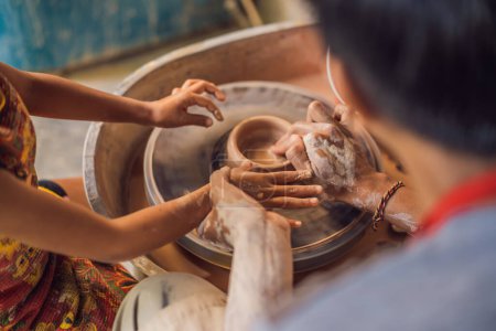 Foto de "Padre e hijo haciendo maceta de cerámica en taller de cerámica
" - Imagen libre de derechos