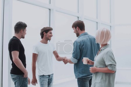 Photo for "colleagues shaking hands in the office lobby" - Royalty Free Image