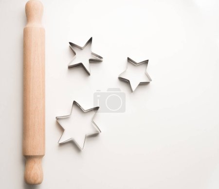 Foto de Vista de ángulo alto de rodillo y estrellas cortador de galletas en la mesa blanca - Imagen libre de derechos