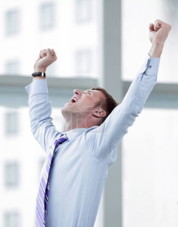 Photo for "Businessman celebrating with his fists raised in the air" - Royalty Free Image