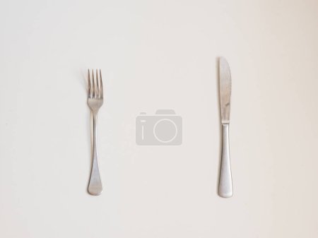 Photo for Food background - high angle view of fork and knife on white table - Royalty Free Image
