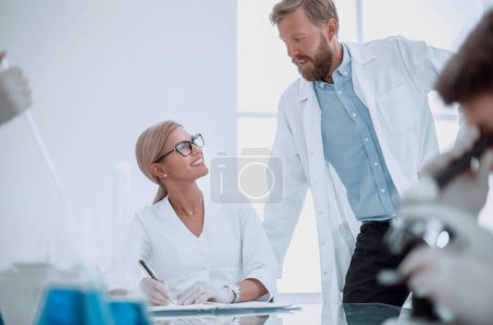 Photo for Female scientist taking notes in a laboratory journal. - Royalty Free Image