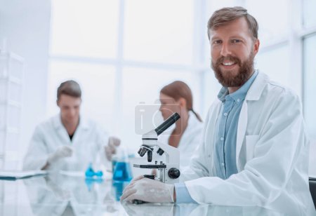 Photo for Successful young scientist sitting at his Desk in the laboratory - Royalty Free Image