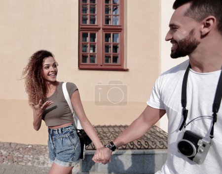 Photo for Couple of tourists look at each other and walking - Royalty Free Image