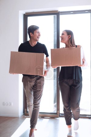 Téléchargez les photos : Heureux jeune couple porte de grandes boîtes en carton. - en image libre de droit