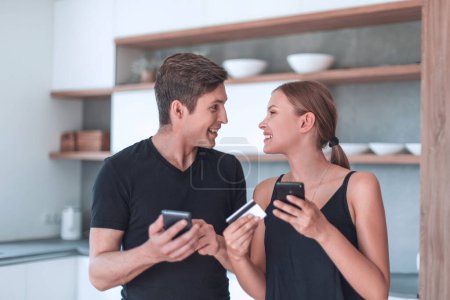 Téléchargez les photos : "jeune couple utilise smartphone pour commander de la nourriture à la maison" - en image libre de droit