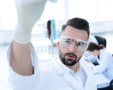 Photo for Image is blurred. young scientist holding tube with the reagents - Royalty Free Image