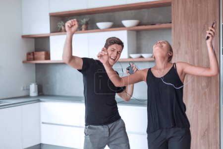 Foto de Feliz pareja joven bailando en su nueva cocina. - Imagen libre de derechos