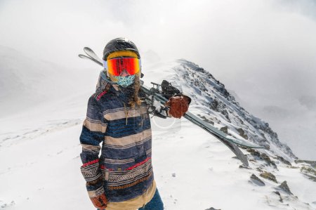 Téléchargez les photos : "Portrait d'une jolie skieuse active, portant un masque et tenant des skis dans ses mains, vacances d'hiver actives" - en image libre de droit