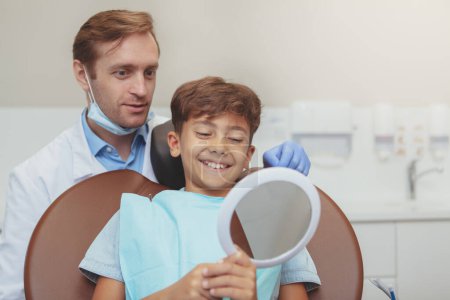 Téléchargez les photos : "Heureux jeune garçon en bonne santé à la clinique dentaire" - en image libre de droit