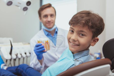 Photo for "Charming young boy getting teeth checkup at the dentist" - Royalty Free Image