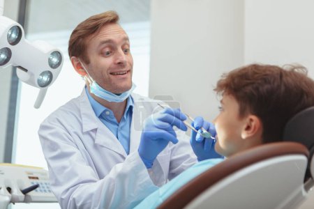 "Charming young boy getting teeth checkup at the dentist"